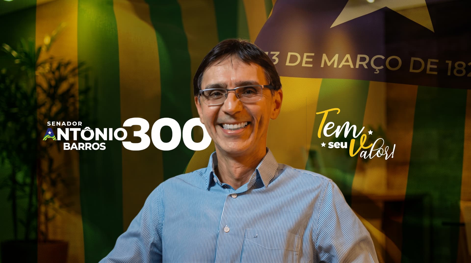 Antônio Barros, candidato ao Senado pelo Piauí, sorrindo diante da bandeira do Piauí