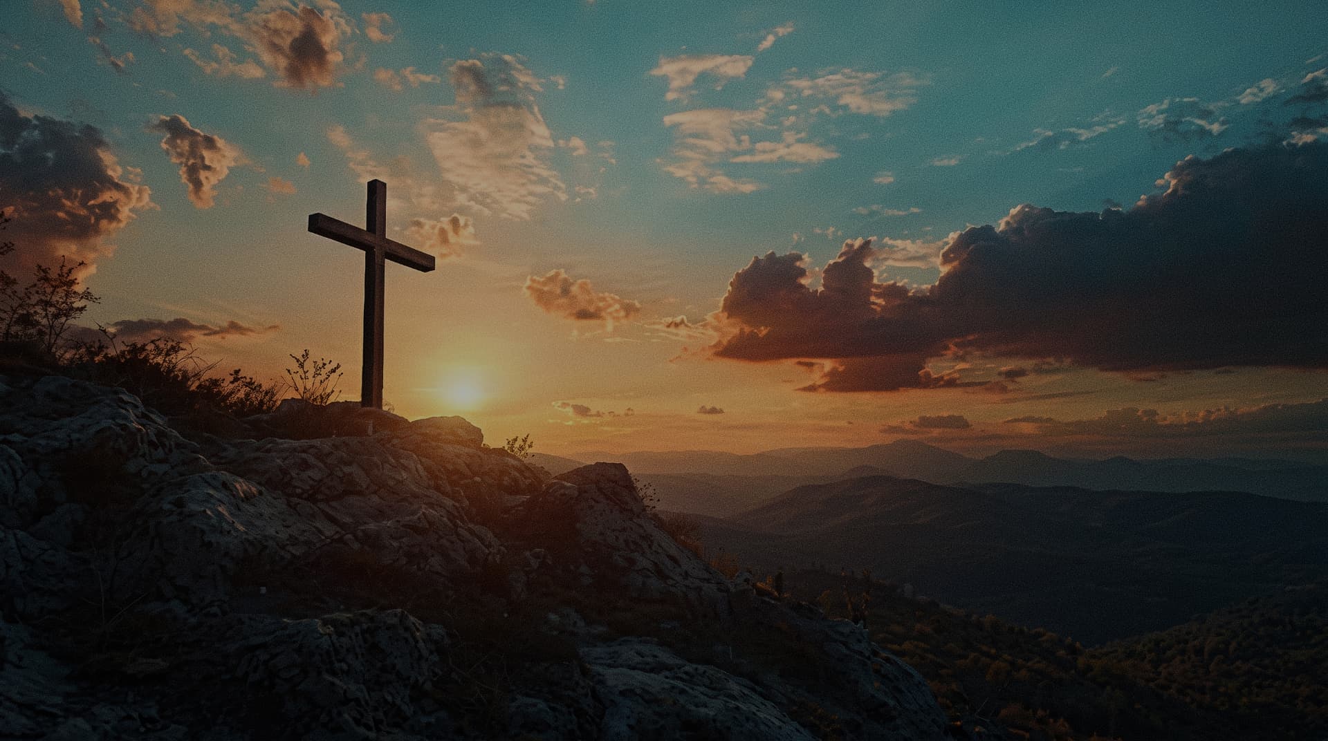 Cruz ao pôr do sol em uma montanha
